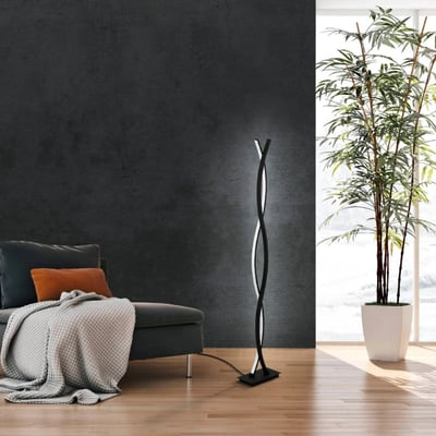 EGLO Lasana gulvlampe i sort med en drejet form, der lyser op med 4700 lm hvidt lys. Lampen står på et trægulv ved siden af en sofa og en stor grøn plante.