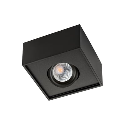 Nærbillede af et sort SG Armaturen Cube Lux loftspot med indbygget LED-lys og reflekterende linse, sat i relief på en matsort ramme.