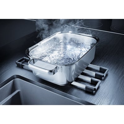 Blanco Etagon 500-U UXI køkkenvask i antracit komposit med en gryde med kogende vand placeret på et praktisk tilbehørsstativ over vasken.