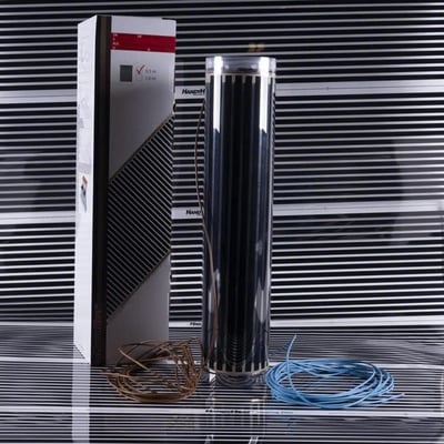 Jevi parketvarme pr. m2 produkt vist med emballage, en opdateret varmefilm og tilhørende kabler på en sort stribet baggrund.