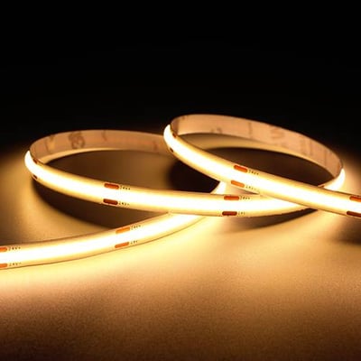 Ansell Lighting C-Cell COB-LED-bånd på 5 meter med varmt hvidt lys, lagt i løkker og tændt mod mørk baggrund.