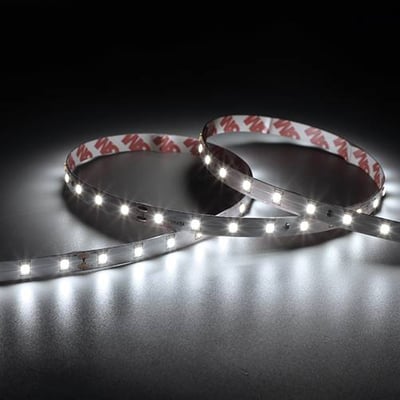 To sammenrullede Ansell Lighting E-Cell Eco LED bånd med 3M tape og synlige lysdioder på mørk baggrund.
