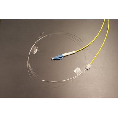 LC/UPC pigtail med gul, LSZH kabel og G657A fiber, 12 meter lang, vist på mørk baggrund.