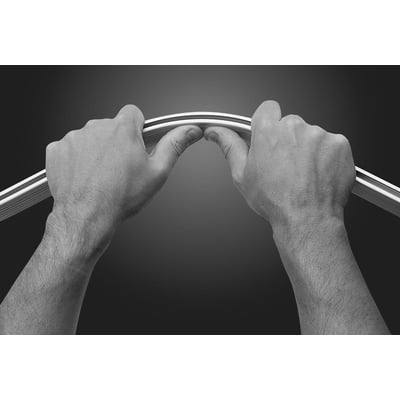 To hænder bøjer en Hefe bendy forhængsstang i krom satin med mat overflade.