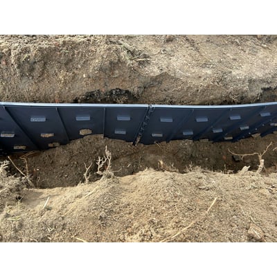 GreenMax TRG45 rodguidepanel i sort plast installeret i jorden for at styre planterødder på en 450 x 600 mm overflade.