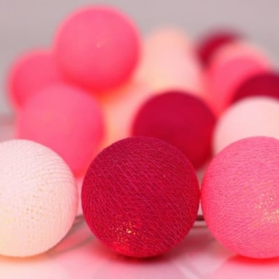 Nærbillede af Irislights lyskædes stofkugler i pink og hvid, hvor LED-lyset skinner igennem det vævede materiale.