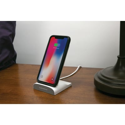 Scosche Qi Dock/Powerbank med opladet iPhone, vist fra siden på et træbord i et hjemmemiljø.