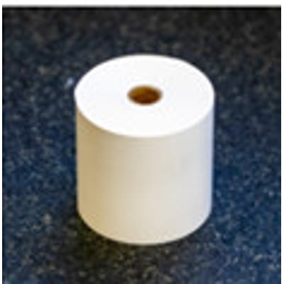 En rulle metrisk printerpapir til DP-1VR modellen, placeret på en mørk og plettet overflade.