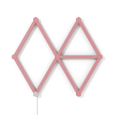 Otte Nanoleaf Lines Skin elementer i mat pink monteret i et geometrisk mønster på en hvid væg.