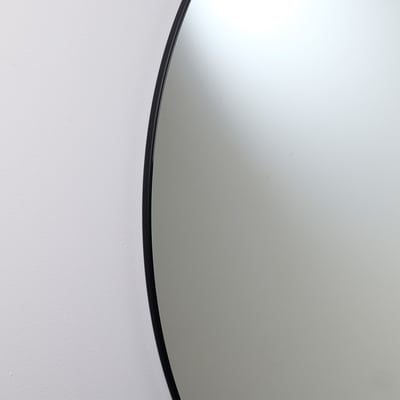 Loevschall Kontur spejl, Ø80 cm, sort, med en tynd sort kant og et svævende look mod en hvid væg.