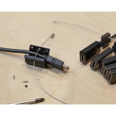 Deltaco HDMI pigtail adapterring i sort med fem forskellige stik, herunder USB-C, DP, Mini DP, Mini HDMI og Micro HDMI, på et træbord.