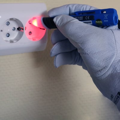 Elit AC10 berøringsfri polsøger tester et stikkontakt, med rød lysindikation af strøm.