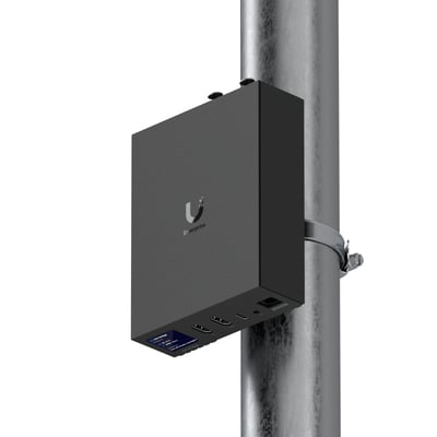 Ubiquiti Enterprise Audio/Video Bridge, en sort AV-bro monteret på en mast med logo og tilslutninger synlige.