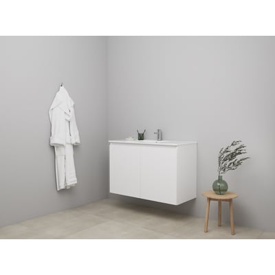 Sanibell Online møbelsæt 101x46 cm i mathvid med 2 grebsfrie softclose låger, vist i et badeværelsesmiljø med hængende badekåbe og lille bord med vase.