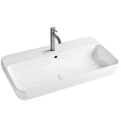 Hvid, firkantet Lavabo Legacy 100 håndvask i porcelæn set skråt ovenfra med synligt armatur og overløb.