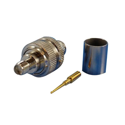 RP SMA hun crimp konnektor i metal med gulddetaljer, vist med crimpkontakt og beskyttelseshylster på hvid baggrund.