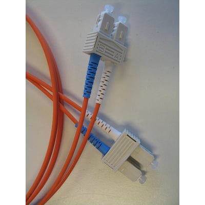 Orange fiberoptisk patchkabel med SC/PC duplex konnektorer, mærket A og B, forbundet i et netværksmiljø.