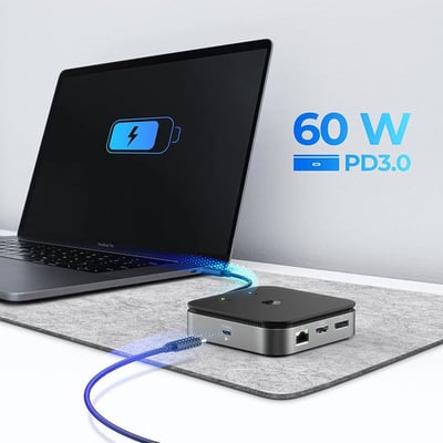 ICY Box USB4 dockingstation med 60W PD3.0 strøm tilsluttes en laptop, hvilket viser en opladningsindikator på skærmen.