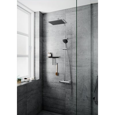 Moderne Damixa Slate 4 brusesystem med stort firkantet hovedbruser og lille håndbruser, i krom og sort, monteret på grå klinkevæg ved et vindue.