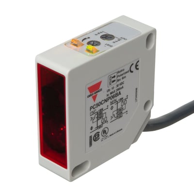 Carlo Gavazzi fotoaftaster PC50CNP06BA med rød frontflade og kabel, set skråt forfra med justeringsknapper på toppen.