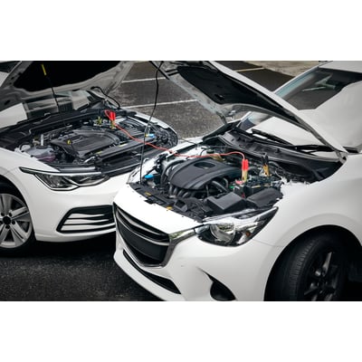 Osram startkabler forbinder to hvide biler med åbne motorhjelme, viser tilslutning til batterier.