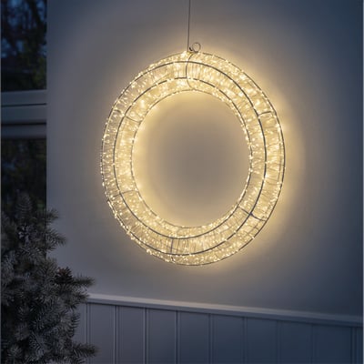 Veli Line metal lyskrans med 480 hvide LED-lys, monteret på en facade om aftenen og lyser op med varmt hvidt skær.