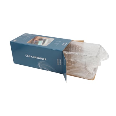 Nordic Quality dåseholder i transparent plastik, delvist pakket ud af sin blå æske med produktillustrationer.