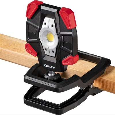 Detalje af Coast CL40R arbejdslampe med clip-fod fastgjort til en træbjælke, med synlig LED-lyskilde.