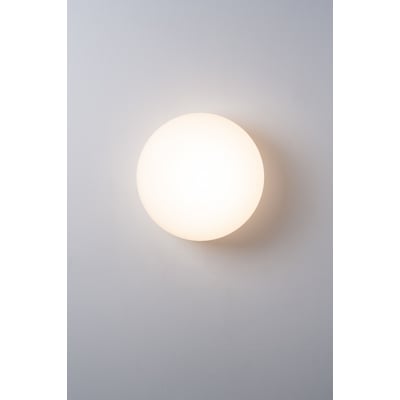 Ifö Electric Solenne 360/175 loft- og væglampe, rund, hvid og mat opalglas på en grå væg.