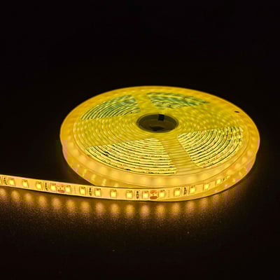 Gul LED strip på en rulle med sort baggrund, viser den lysende gule farve og 120 LED pr. meter.