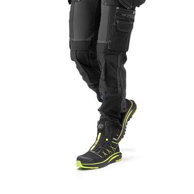 Activewear Chipper 5200 vintersikkerhedsstøvle i str. 48 ses på benet, med sort overdel og neongule detaljer.