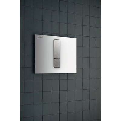 Laufen Lis AW102 betjeningsplade i hvidt glas med dobbeltskyl og børstet stålknapper monteret på mørkegrå vægfliser.
