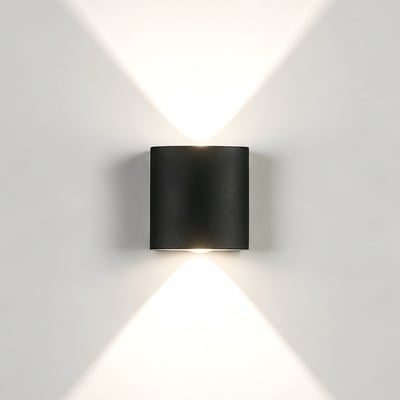 LEDlife 2W CURVE sort op/ned-væglampe monteret på væg med lys, der stråler opad og nedad.