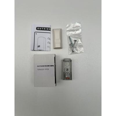 TR3 udefølerens komponenter: monteringsvejledning, hvidt sensorhus, skruer og dybler i pose samt selve føleren med terminalblok.