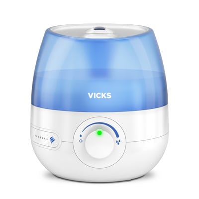 Vicks Mini Cool Mist luftfugter med blåt vand, der udsender kølig tåge for at forbedre indeklimaet.