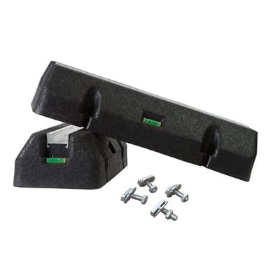 To sorte montagefødder af gummi til varmepumper, hver med et integreret vaterpas, og fire gevindbolte til montering, vist på hvid baggrund.