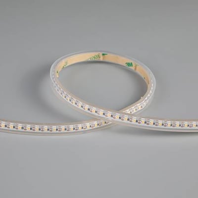 Ansell Lighting K-Cell LED bånd på 5 meter, 7,5mm bredt og IP67-klassificeret, vist i en bue på en grå baggrund.