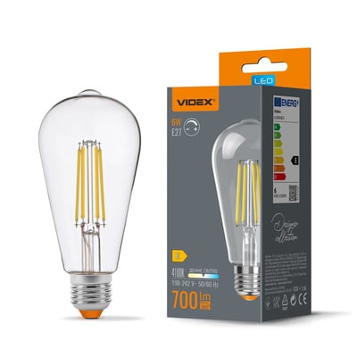Videx dæmpbar ST64-filament LED-pære med E27-fatning, 6 W og klart glas vist ved siden af emballagen.