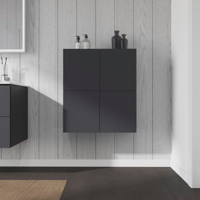 Duravit LC halvhøjskab i grafit mat med to låger, monteret på en lysegrå træbeklædt væg, med dekorationsgenstande ovenpå.