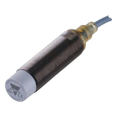 Carlo Gavazzi induktiv sensor M18 med gevindhus, grå sensorfront og tilsluttet kabel, vist skråt forfra.