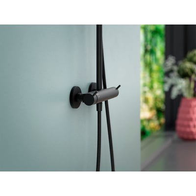 Mora lige forskruning i mat-sort monteret på en lyseblå væg med en brusehovedslange tilsluttet.