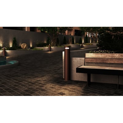 Ansell Lighting Avio pullert med sort halvskærm oplyser en udendørs terrasse med fliser og bænk om aftenen.