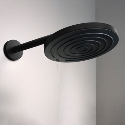 Hansgrohe Ecostat Comfort S Pulsify S hovedbruser i mat sort, med vand der løber fra dyserne ned ad den hvide væg.