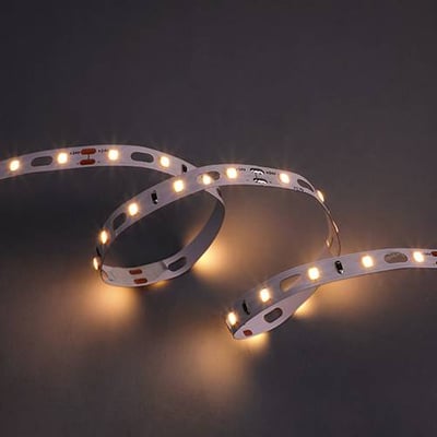 Ansell Lighting Z-Cell LED bånd med varmt hvidt lys, snoet og belyst på en mørk baggrund for at vise lysstyrken.