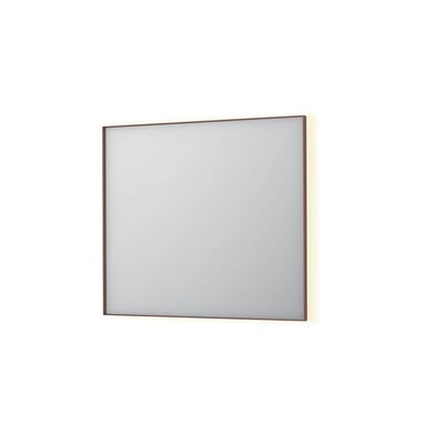 Sanibell INK SP32 LED spejl på 90x80 cm med børstet kobber ramme, der viser indirekte lys fra bagsiden på en hvid baggrund.