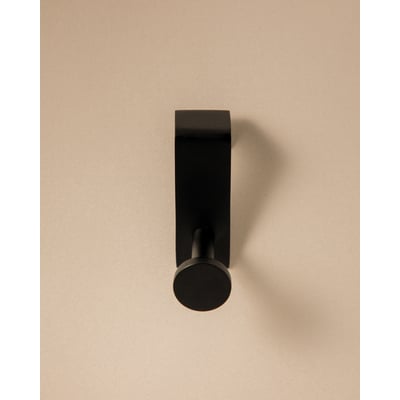 Cosmic håndklædekrog i mat sort finish, viser krogens moderne design med diskret cirkulær afslutning på en lys baggrund.