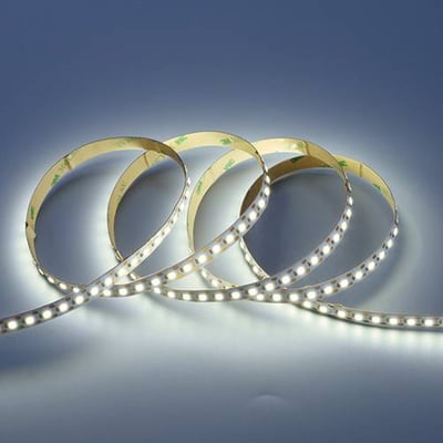 Flere slyngninger af et tændt Ansell Lighting K-Cell LED bånd med kold hvidt lys og 10mm bredde.