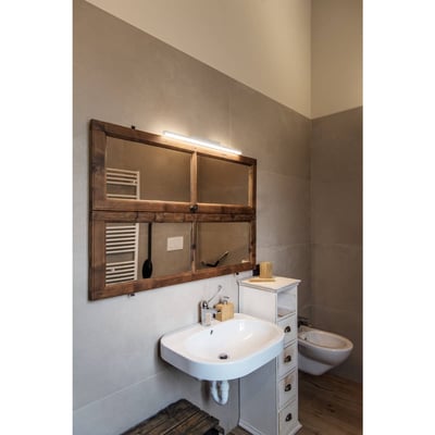 SLV Glenos 60 LED spejllampe monteret over et rustikt spejl på en badeværelsesvæg, giver jævn belysning.