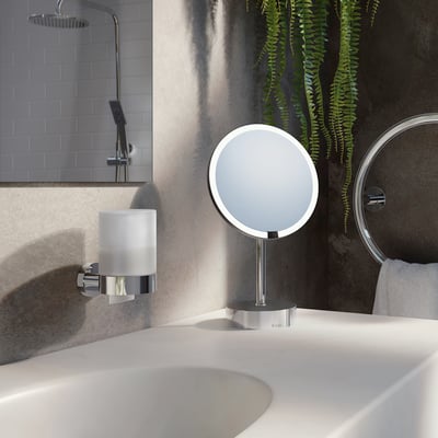 Smedbo Home sæbedispenser i poleret krom med matteret glasbeholder monteret på væggen ved siden af en vask.