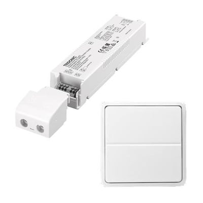 Lauritz Knudsen 60W/24V LED-driver og trådløst tryk til Fuga, sat sammen på hvid baggrund.